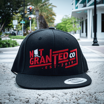 Black cap with red and white text on a street background